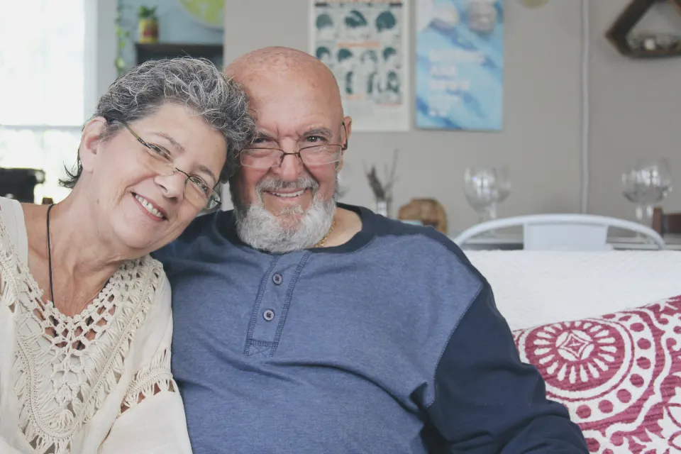 Casal de idosos sorrindo juntos em casa
